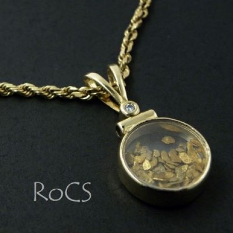 Gold pendant filled with gold flakes and set with diamond and sapphire image